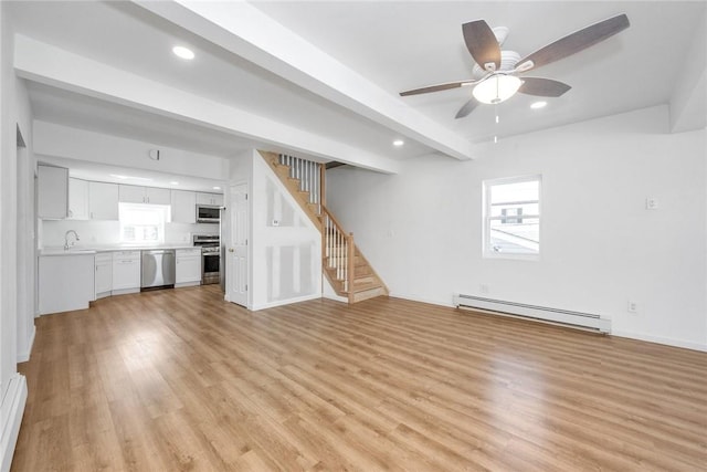 unfurnished living room featuring ceiling fan, sink, beam ceiling, a baseboard radiator, and light hardwood / wood-style floors