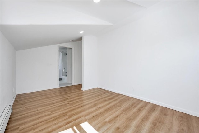 unfurnished room with vaulted ceiling, light hardwood / wood-style floors, and a baseboard radiator