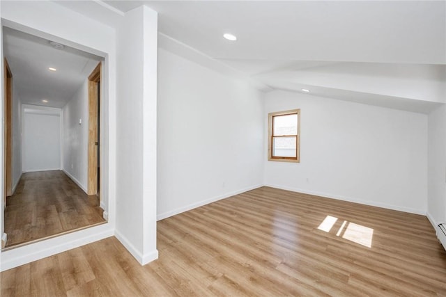 additional living space with light hardwood / wood-style flooring and vaulted ceiling