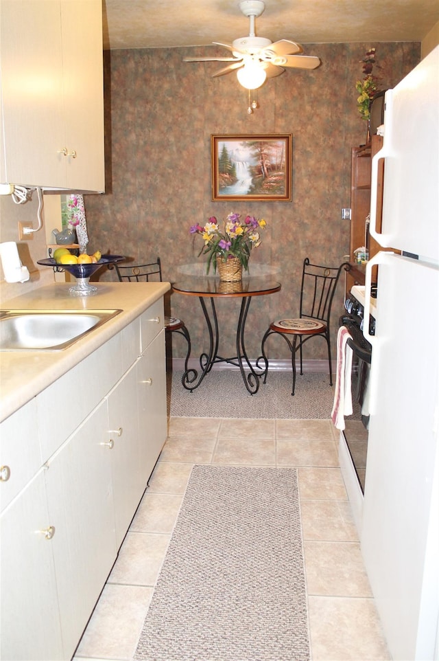 kitchen featuring ceiling fan, sink, light tile patterned flooring, and white refrigerator