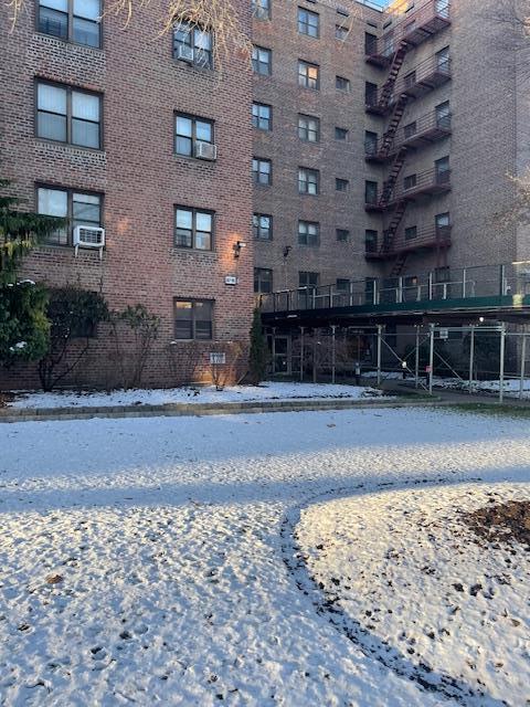 snow covered building featuring cooling unit