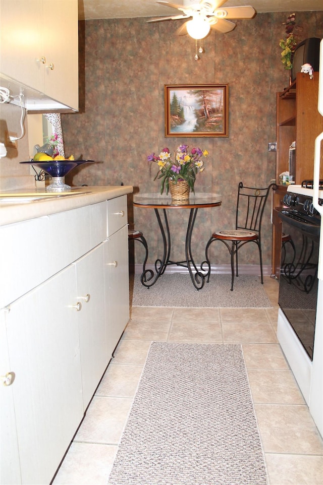 87-10204 204 Steet Unit A-62, Hollis, NY 11423 - kitchen with ceiling fan, range with gas cooktop, light countertops, white cabinets, and light tile patterned floors
