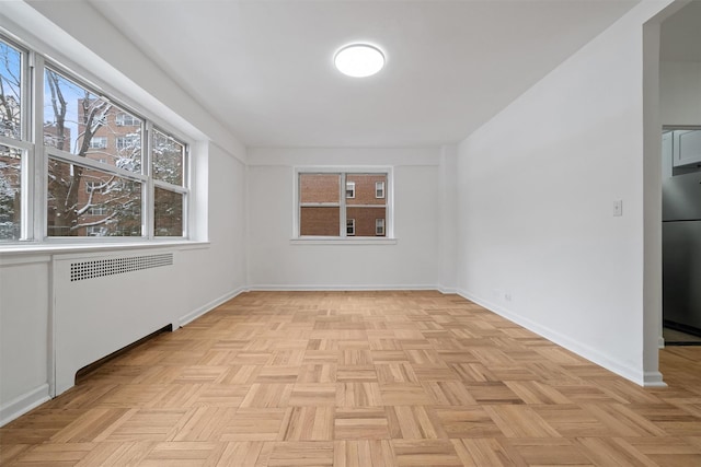 empty room featuring radiator and light parquet floors