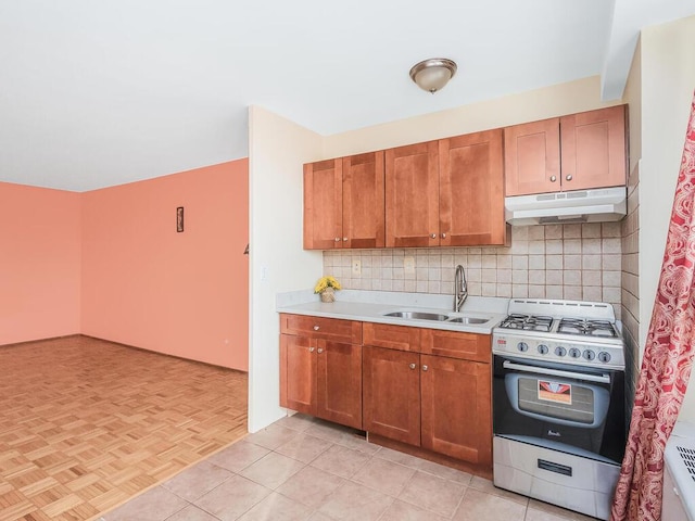 kitchen featuring backsplash, gas stove, sink, and light parquet floors