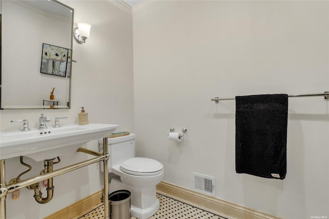 bathroom with toilet and ornamental molding