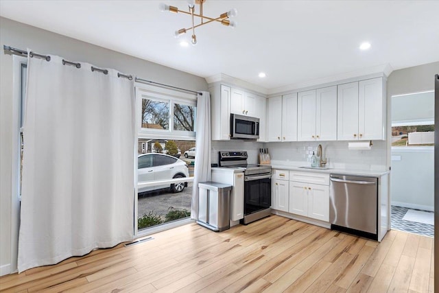 kitchen featuring a wealth of natural light, sink, white cabinets, and stainless steel appliances