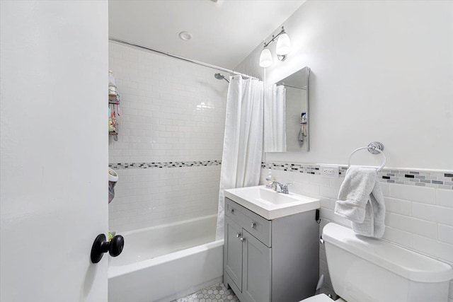 full bathroom featuring shower / bath combo with shower curtain, vanity, tile walls, and toilet