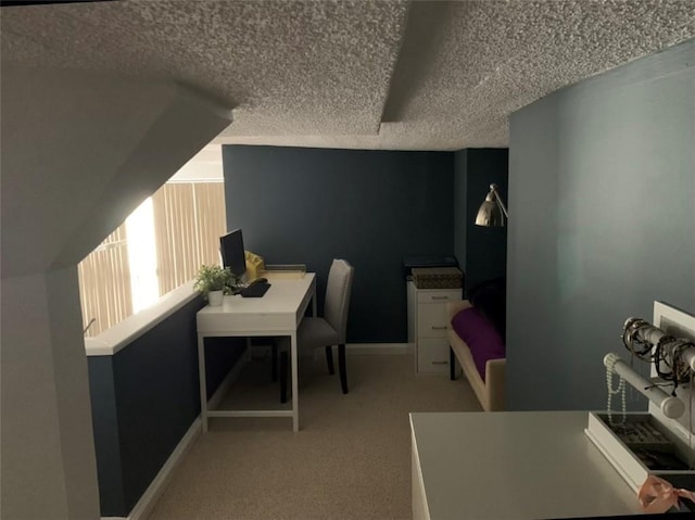 carpeted home office featuring a textured ceiling