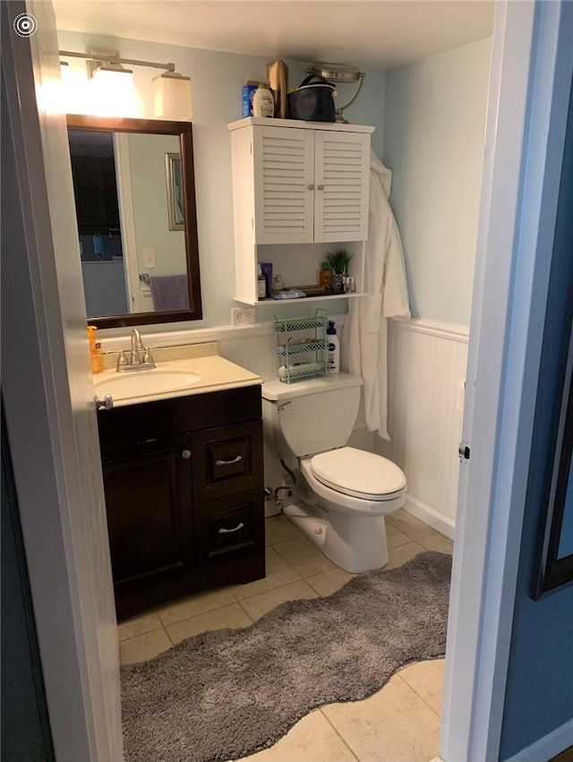 bathroom with tile patterned flooring, vanity, and toilet