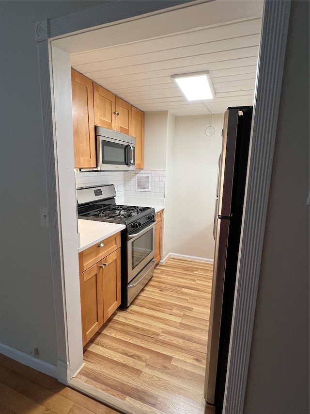 kitchen featuring decorative backsplash, light hardwood / wood-style flooring, and stainless steel appliances