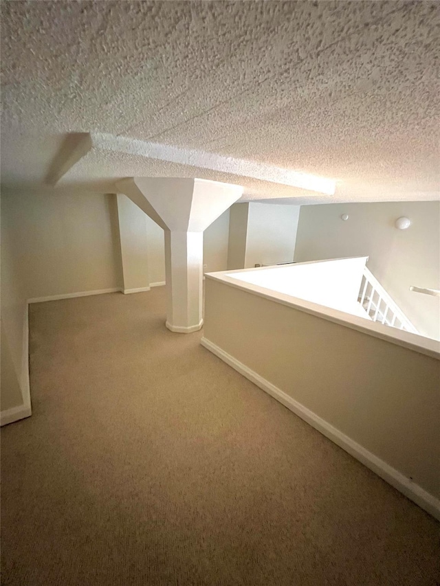 additional living space with carpet and a textured ceiling