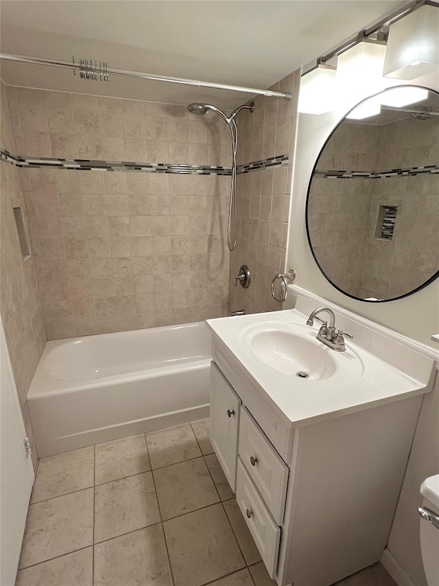 full bathroom featuring tiled shower / bath, vanity, toilet, and tile patterned flooring