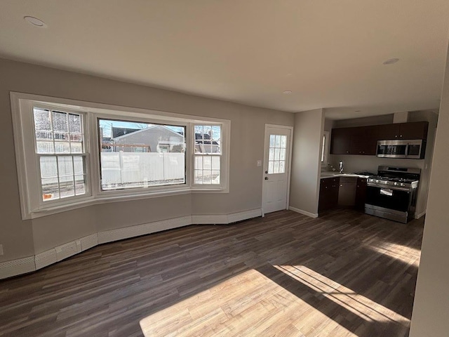 unfurnished living room featuring sink and dark wood-type flooring