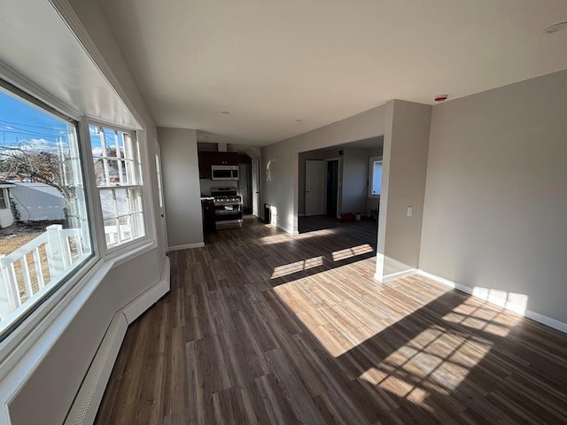 unfurnished living room featuring a baseboard radiator and dark hardwood / wood-style floors