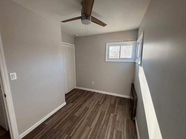 unfurnished bedroom with dark hardwood / wood-style floors, ceiling fan, and a closet