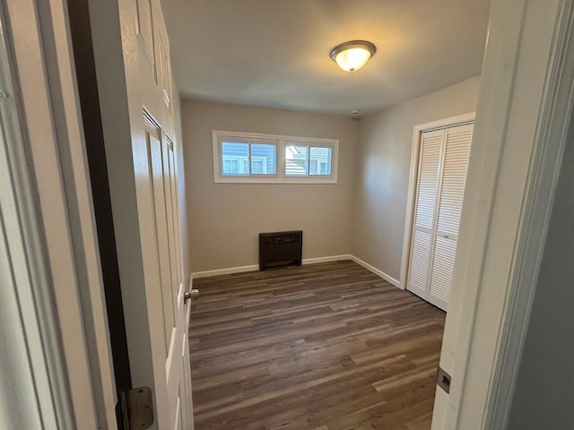 unfurnished bedroom featuring dark wood-type flooring and a closet