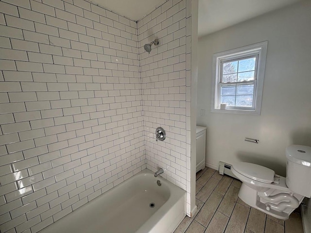 bathroom featuring tiled shower / bath, baseboard heating, and toilet