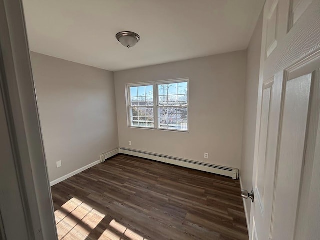 spare room featuring a baseboard radiator and dark hardwood / wood-style flooring