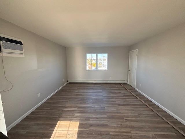 spare room with dark wood-type flooring and a wall unit AC