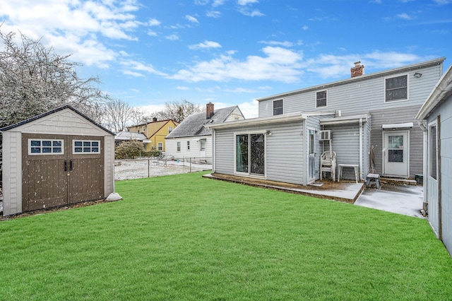 rear view of house featuring a lawn, a patio, and a storage unit