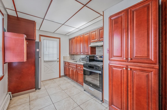 kitchen featuring decorative backsplash, a drop ceiling, stainless steel appliances, a baseboard heating unit, and light tile patterned floors