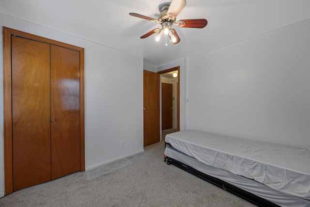 bedroom with light carpet, a closet, and ceiling fan