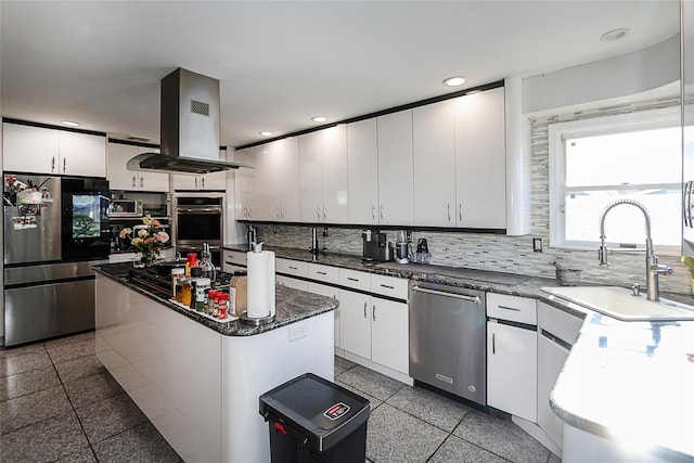 kitchen featuring appliances with stainless steel finishes, island range hood, sink, white cabinetry, and a kitchen island