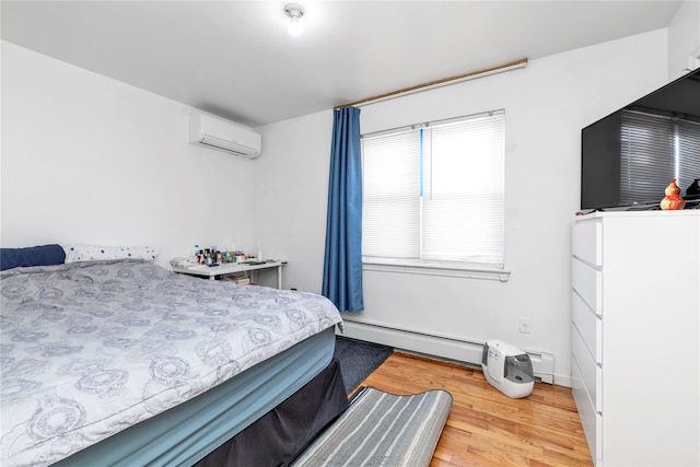 bedroom featuring baseboard heating, a wall mounted AC, and hardwood / wood-style flooring