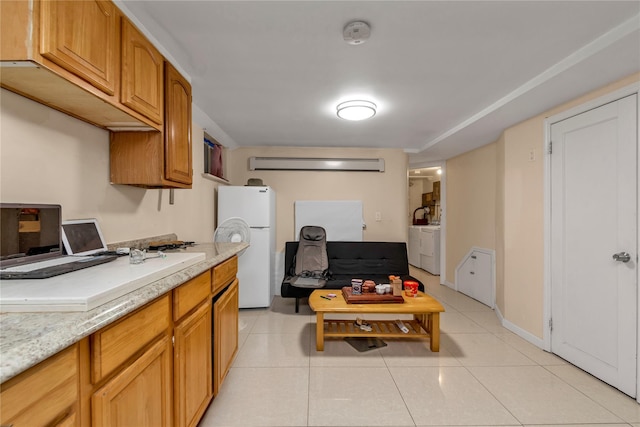 kitchen with white fridge, washer / clothes dryer, light tile patterned floors, and a wall unit AC