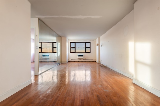 spare room featuring a baseboard radiator and hardwood / wood-style flooring