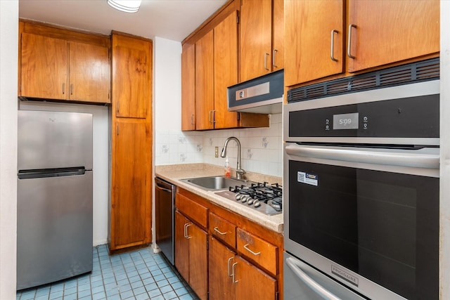 kitchen featuring backsplash, light tile patterned flooring, sink, and appliances with stainless steel finishes