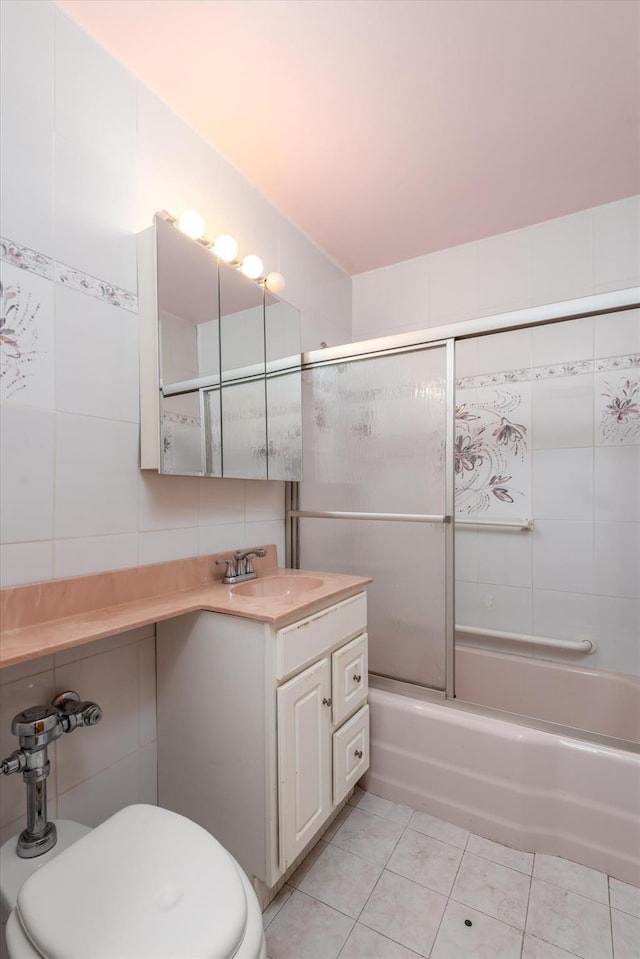 full bathroom featuring tile patterned floors, vanity, bath / shower combo with glass door, and tile walls