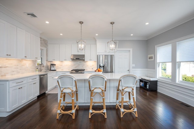 kitchen with pendant lighting, white cabinetry, appliances with stainless steel finishes, and a kitchen island