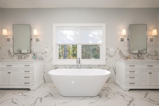 bathroom with a tub to relax in, vanity, and tile walls