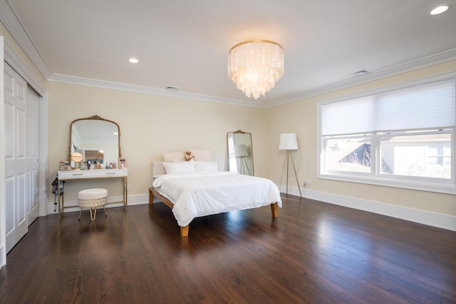 bedroom with a closet, dark hardwood / wood-style floors, ornamental molding, and a notable chandelier