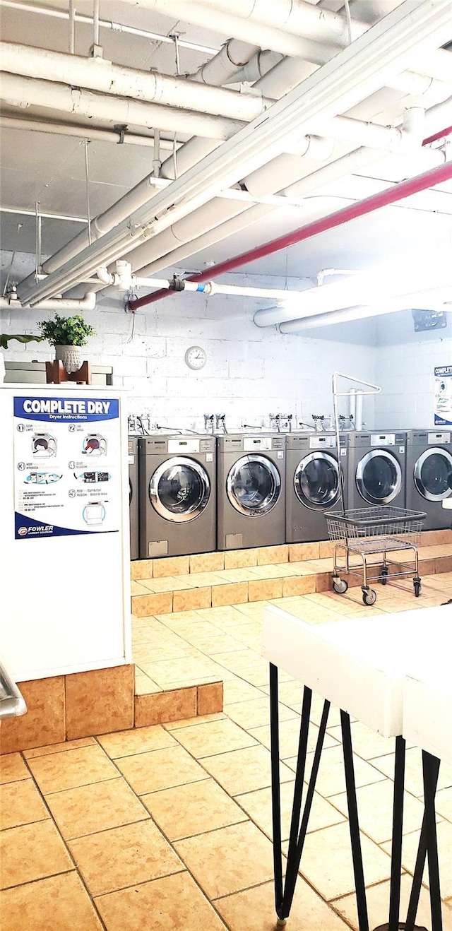 clothes washing area featuring washer and clothes dryer and tile patterned flooring