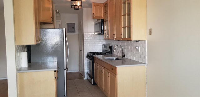 kitchen with sink, backsplash, electric panel, light tile patterned floors, and appliances with stainless steel finishes