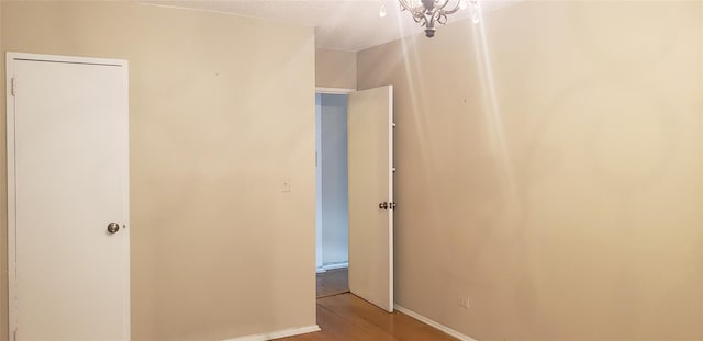 hallway featuring light hardwood / wood-style floors and a notable chandelier