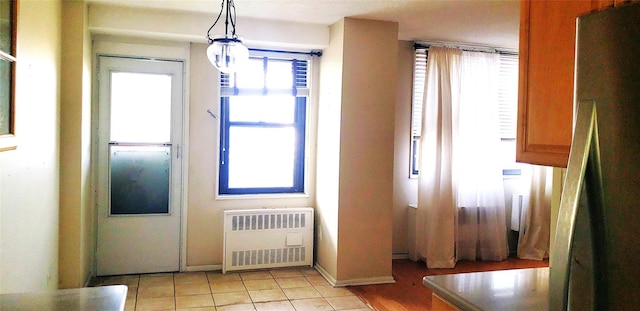 doorway to outside with radiator and light tile patterned floors