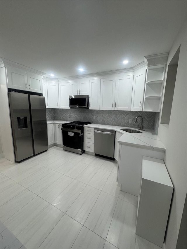 kitchen featuring white cabinets, appliances with stainless steel finishes, light stone countertops, and sink