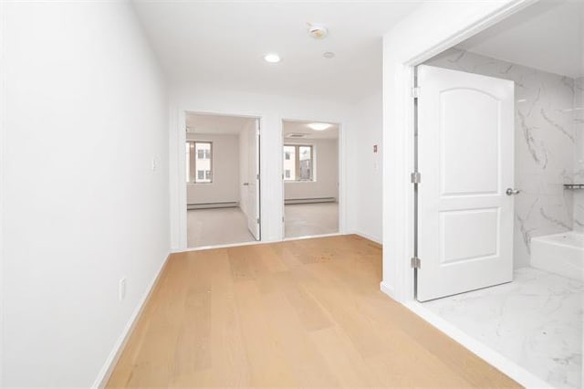 hall featuring baseboard heating and hardwood / wood-style floors