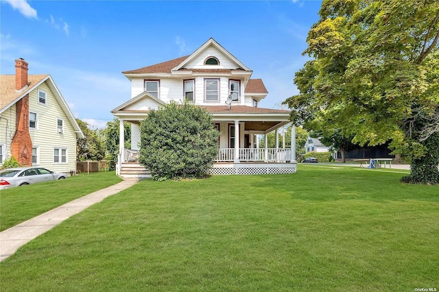 victorian house featuring a front yard and a porch