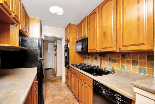 kitchen featuring black appliances, sink, tasteful backsplash, and light tile patterned floors