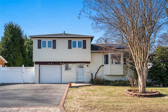 tri-level home with a front lawn and a garage