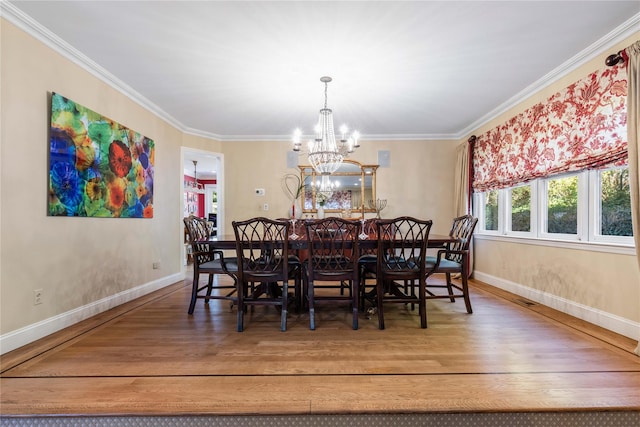 dining space featuring baseboards, ornamental molding, and wood finished floors