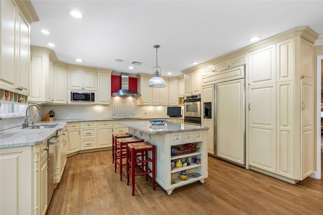 kitchen featuring a kitchen island, hanging light fixtures, wall chimney range hood, open shelves, and a sink