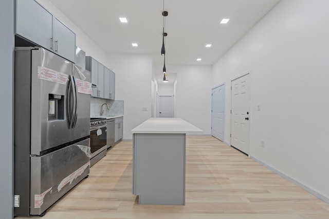 kitchen with backsplash, stainless steel appliances, pendant lighting, a center island, and gray cabinets