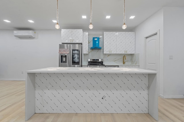 kitchen featuring wall chimney exhaust hood, stainless steel appliances, light hardwood / wood-style flooring, a wall unit AC, and decorative light fixtures