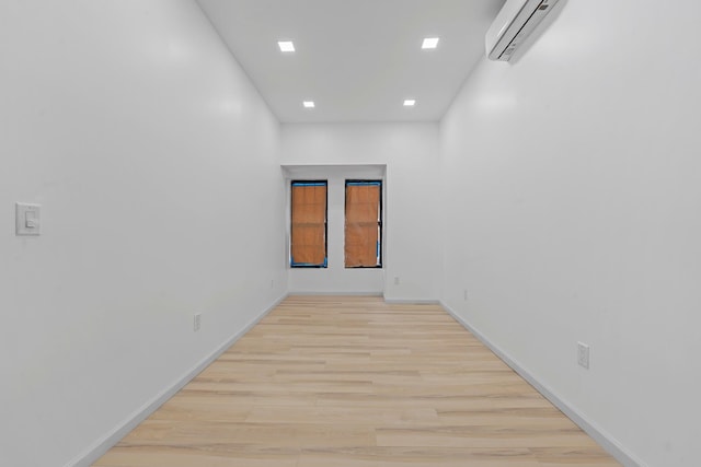 empty room with light hardwood / wood-style flooring and a wall mounted AC