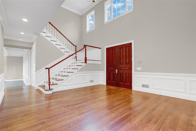 entryway featuring crown molding and light hardwood / wood-style floors